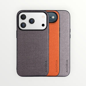 Hostecno iPhone 17 Pro Max textile leather phone case in grey, orange, and light grey. Features a camera cutout.