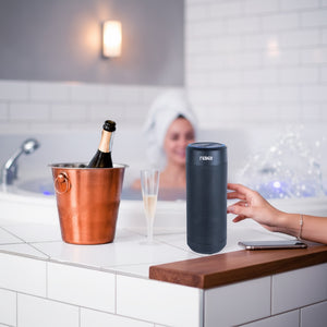 Hostecno Naxa wireless smart speaker in black, with voice control and Wi-Fi/Bluetooth connectivity, shown next to a champagne bucket and flute.
