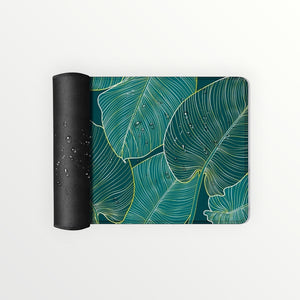 Hostecno teal tropical leaves desk pad with stitched edge and non-slip rubber base. Waterproof design.